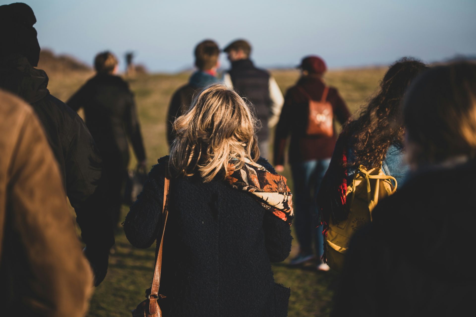 groupe de personnes marchant sur un champ d'herbe